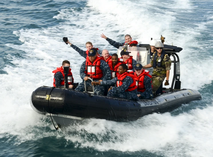 a group of people in red jackets riding on a raft