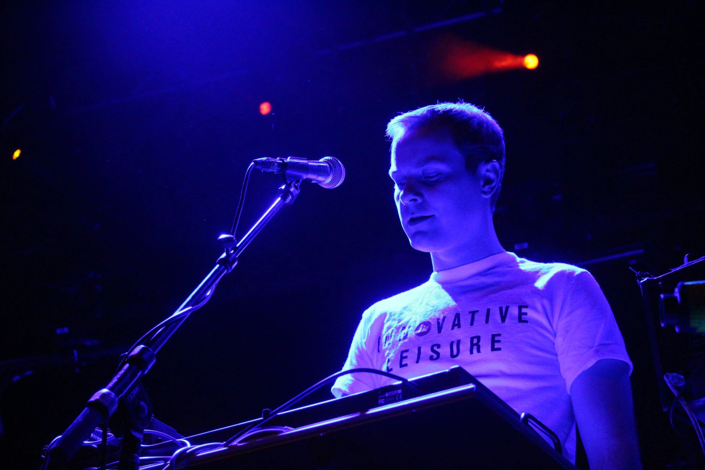 a man at a microphone, singing into a microphone