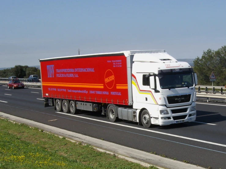 truck traveling down highway next to cars on roadway