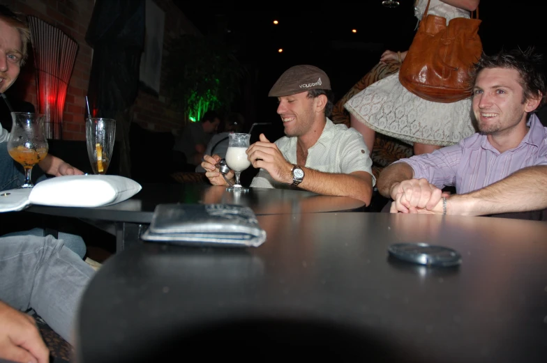 several people sitting at a bar and having drinks