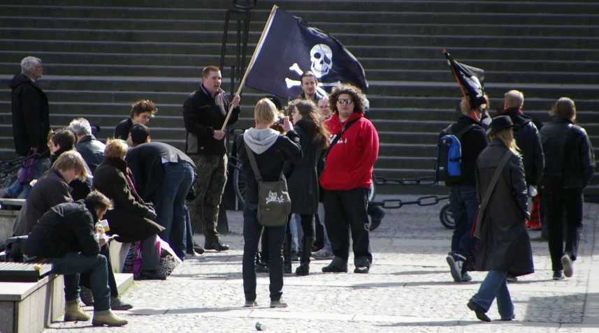 several people walking around with pirate flags in their hands