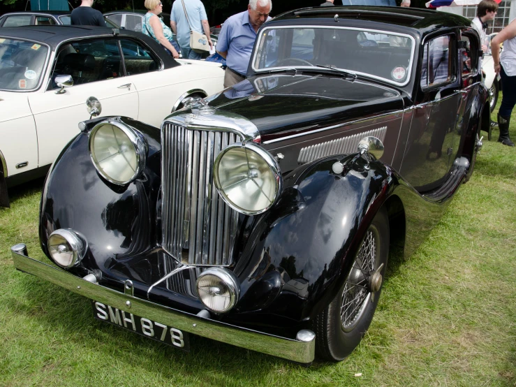 vintage cars and people near one another at an event