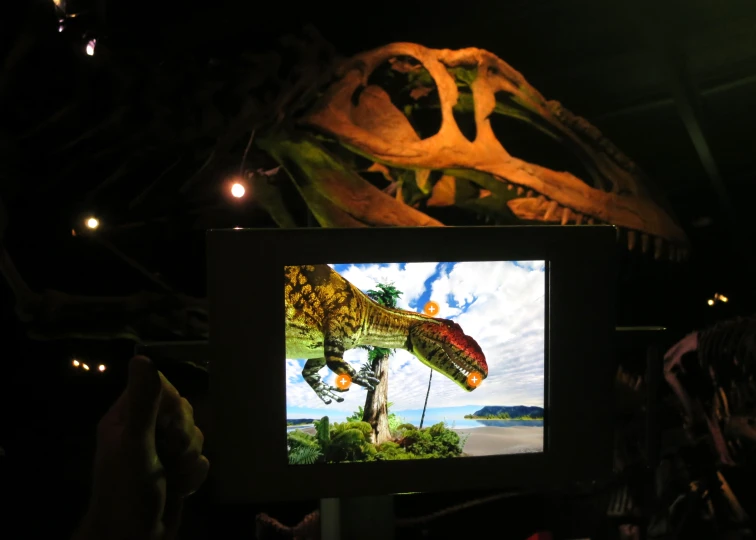 there is a tv showing a dinosaur that's eating a plant