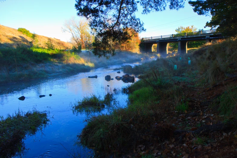 a beautiful river with the sun behind it