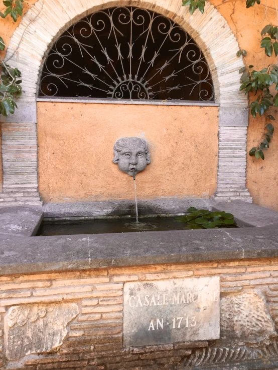 an outdoor fountain surrounded by trees in front of a building