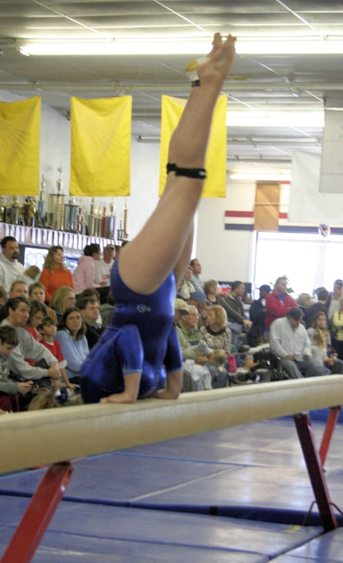 a young man in a blue and yellow shirt doing a hand stand