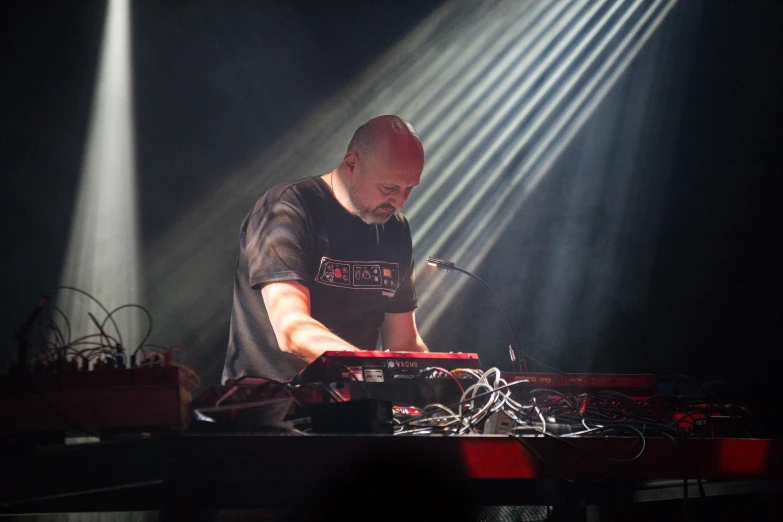 a dj in front of a stage lights playing the keyboards