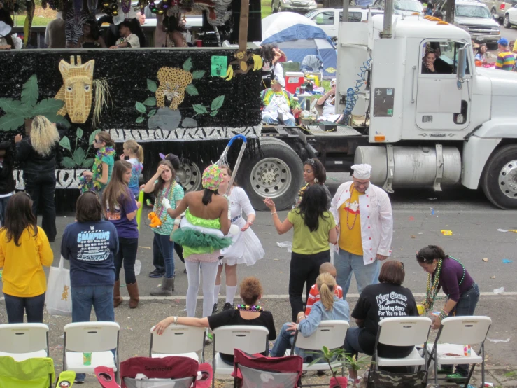 a large truck in the street with many people sitting in front