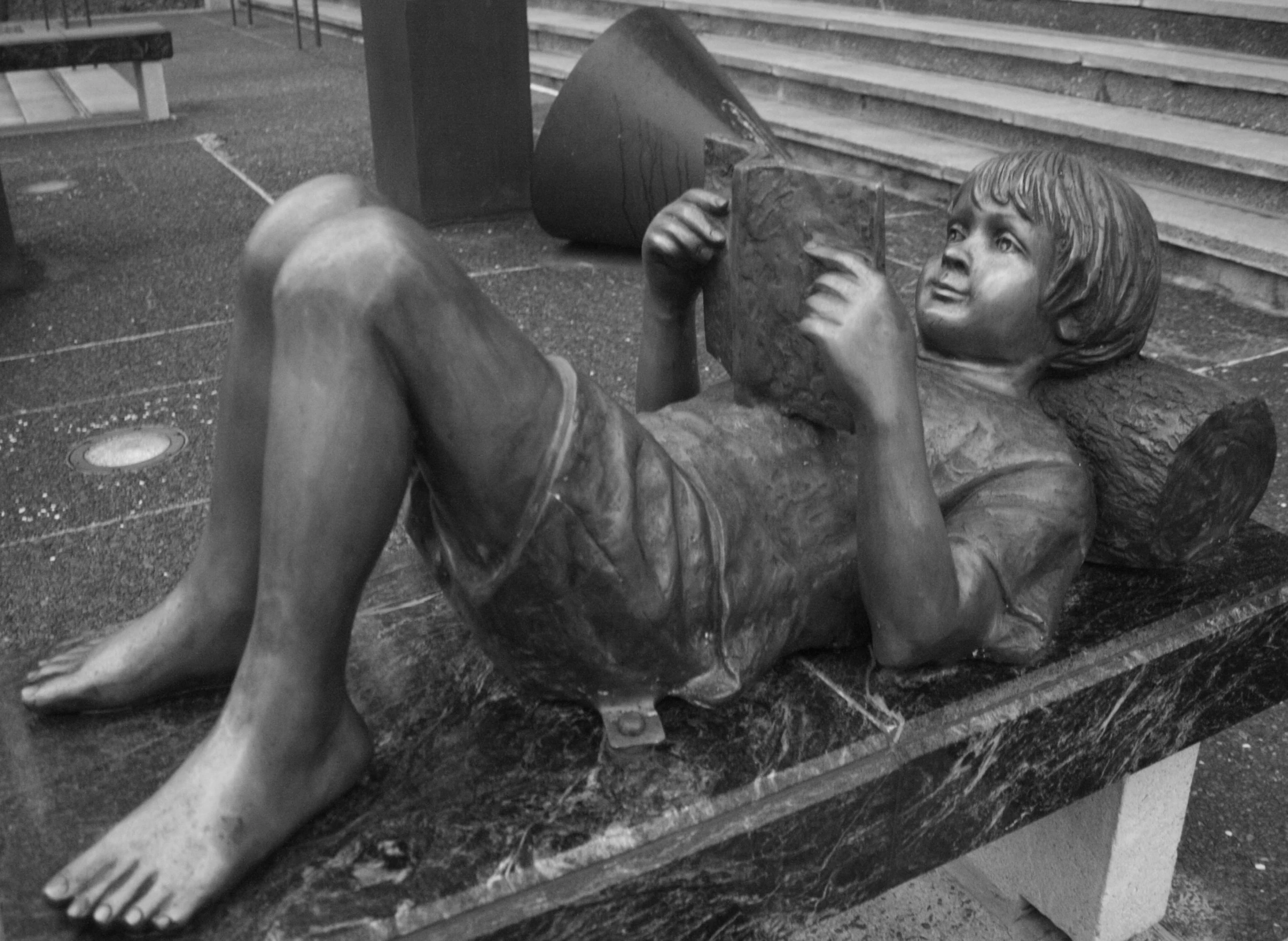 a statue that is sitting on a concrete bench