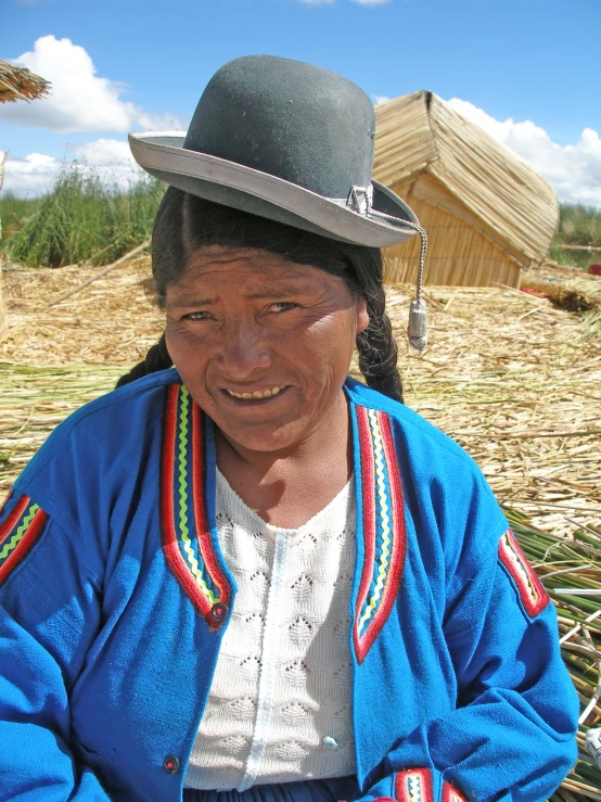 a woman sitting on a ground with her hat
