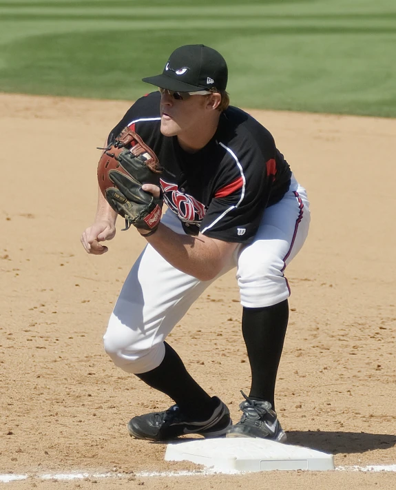 a person on a field playing baseball and bending over