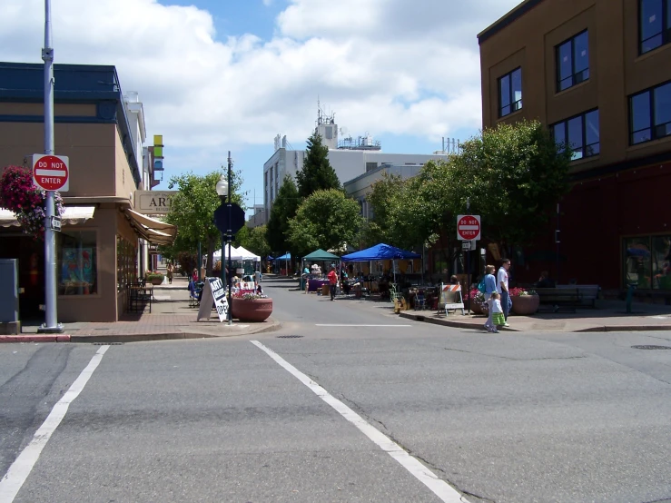 a busy street with several businesses and people walking