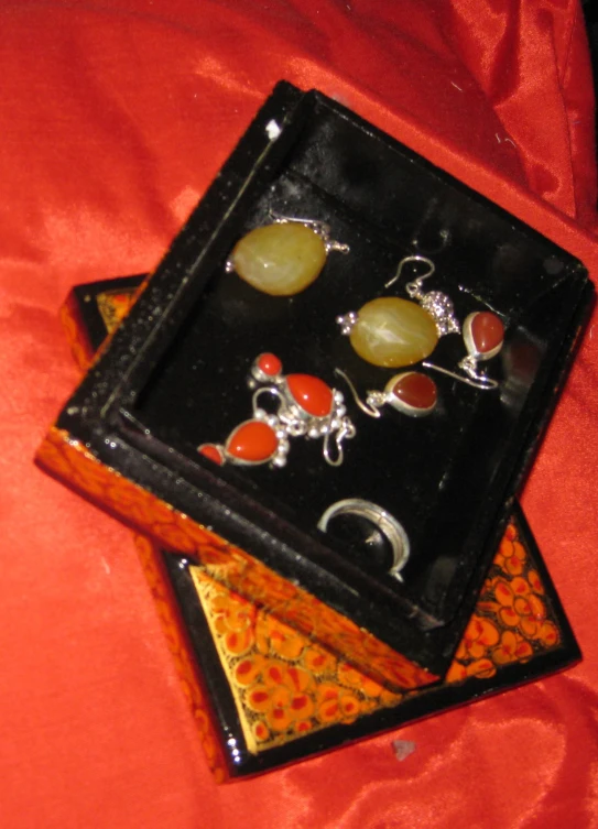 a small black box holds three earrings