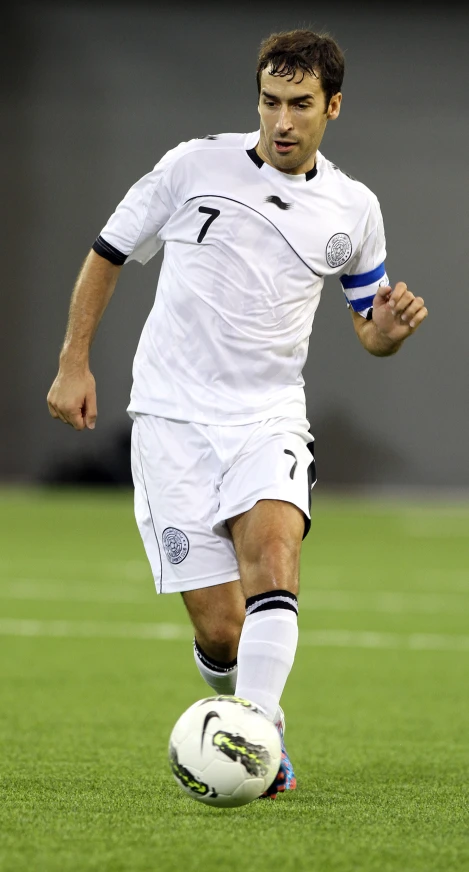 a man in a soccer uniform runs with the ball