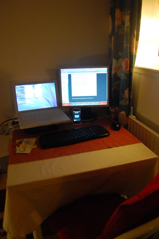 two computers sitting on top of a table