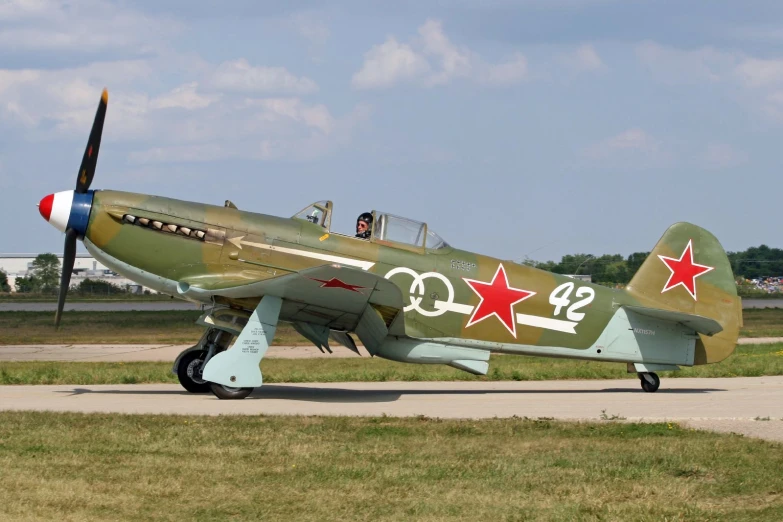 an old time military airplane is on the runway