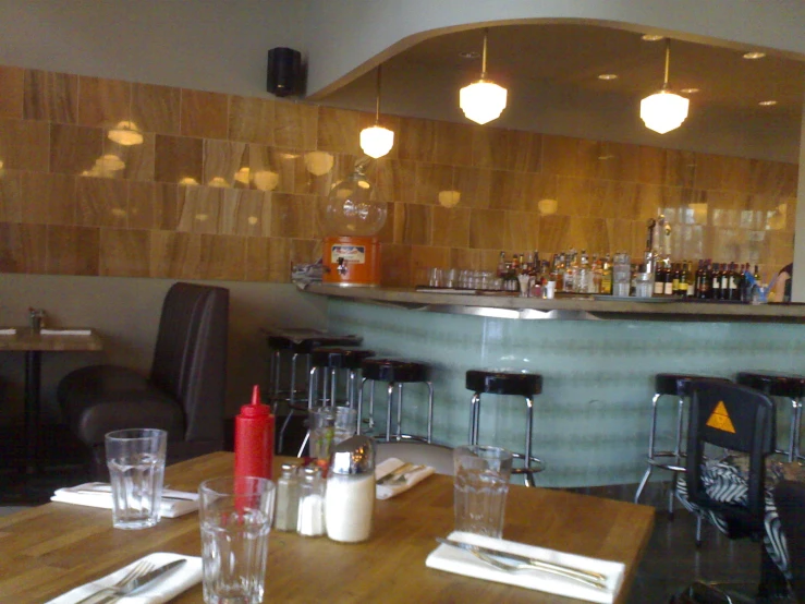 a table has several glasses and a lot of liquor bottles