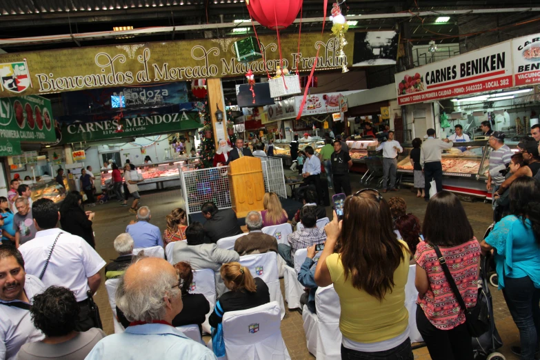 a bunch of people standing around an open market