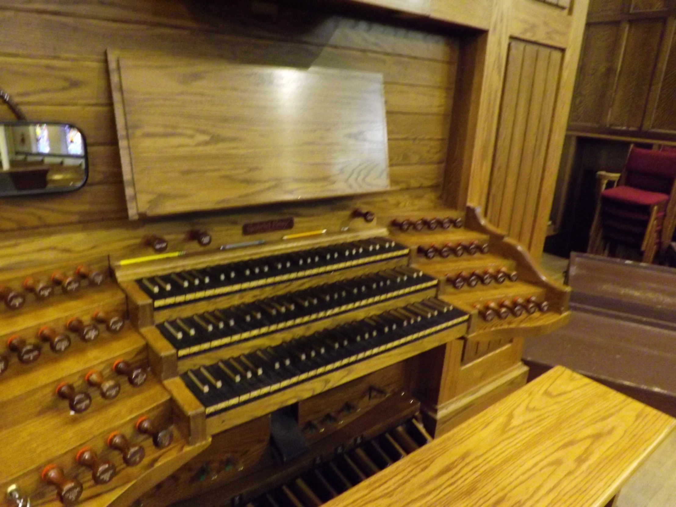 an old looking organ in a church with wooden floors and walls