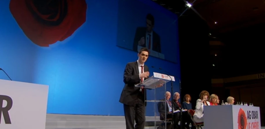 a man standing at a podium and speaking