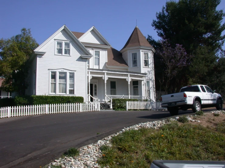 a white house with a pick up truck parked in front