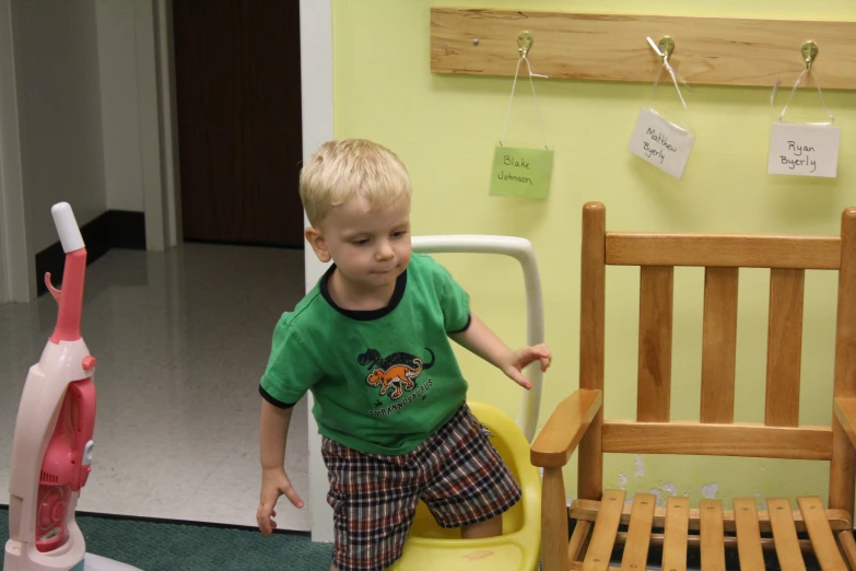 a small boy standing on top of a chair