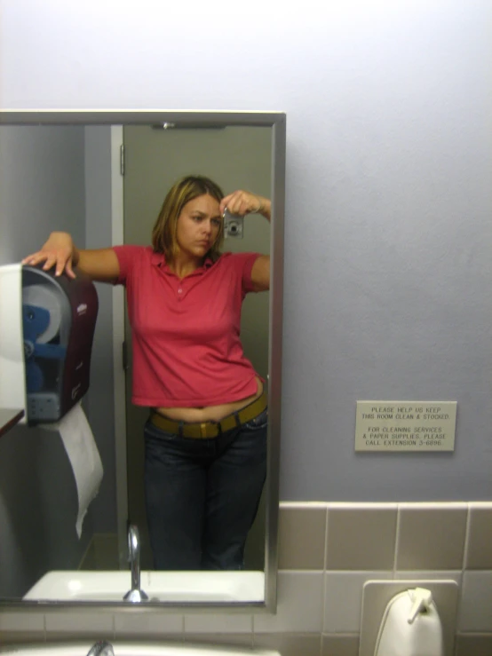 a woman taking a picture of herself in the mirror