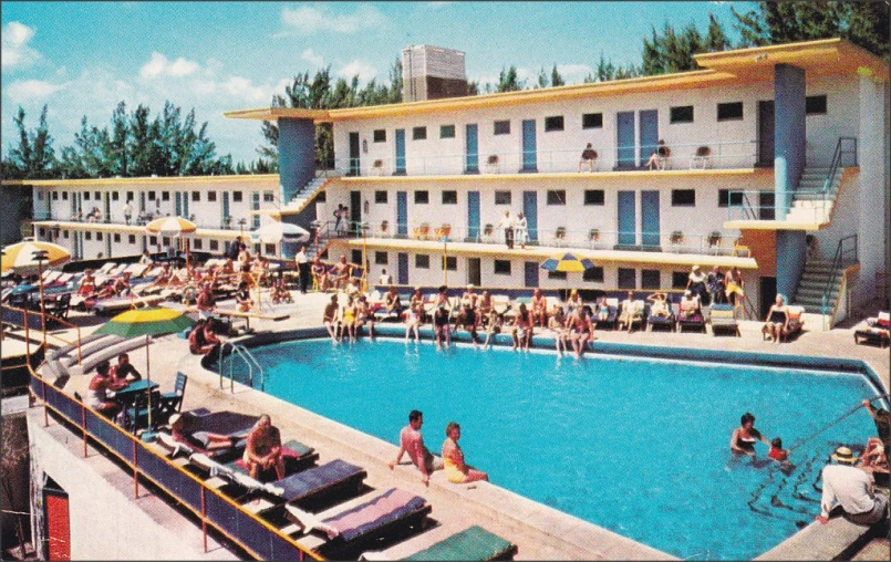 people are gathered around an outdoor pool on a clear day