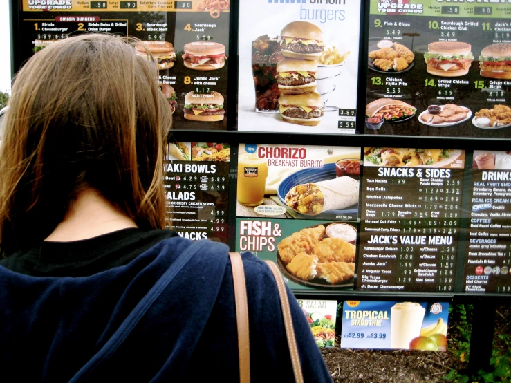 a woman looking at menu for her fast food stand