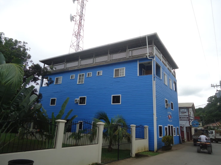 a blue building with many windows and people walking around