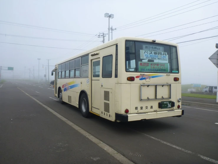 a white bus traveling down a road with power lines