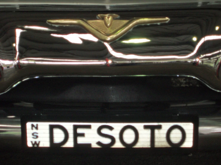 the shiny front bumper on the car with a name plate