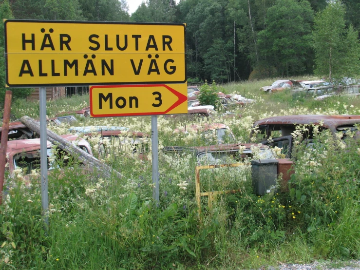 a yellow sign in a field that reads har glutar aliman vag