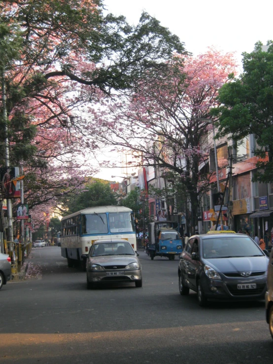 a bus traveling down the road near some parked cars