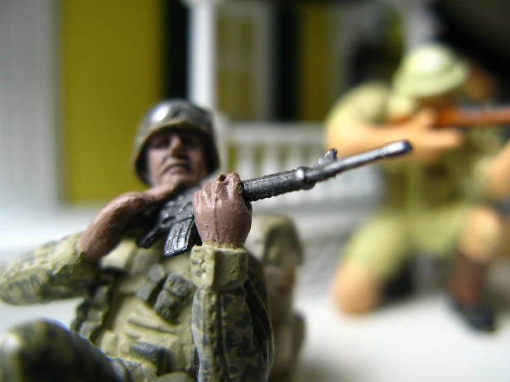 a toy soldier is holding a rifle in the air
