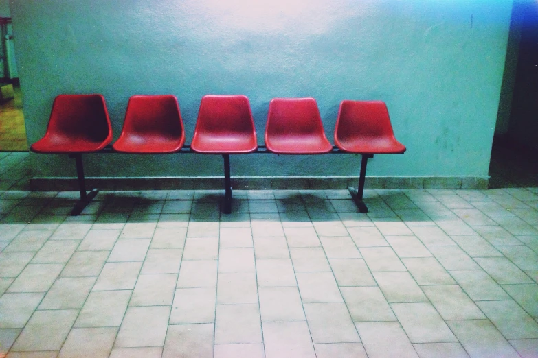 the chairs are lined up against the green wall