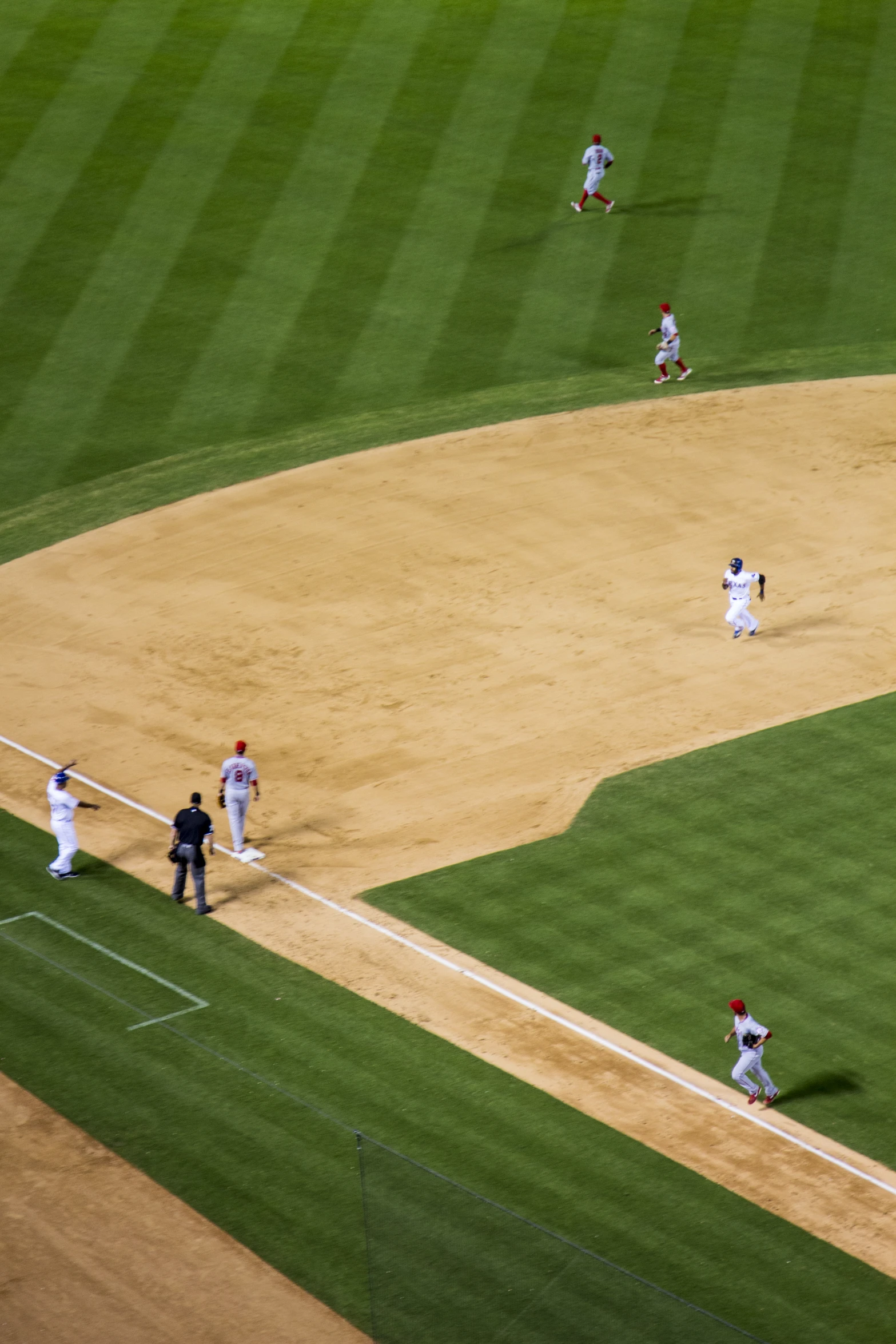 a baseball game in progress with a pitcher at the plate and a catcher on base