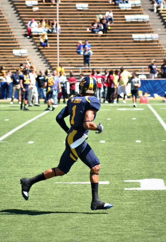 a football player running down the field while wearing a helmet