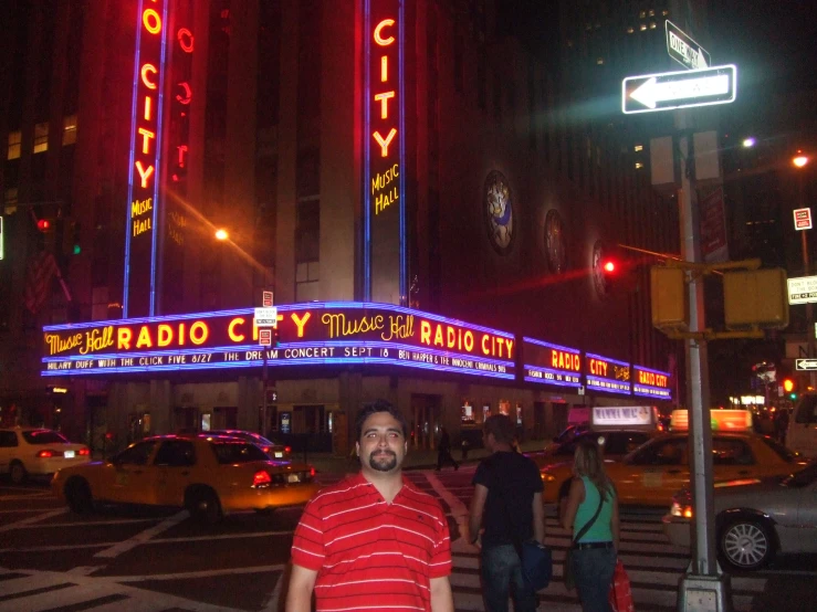 a man is standing at an intersection in the middle of a city