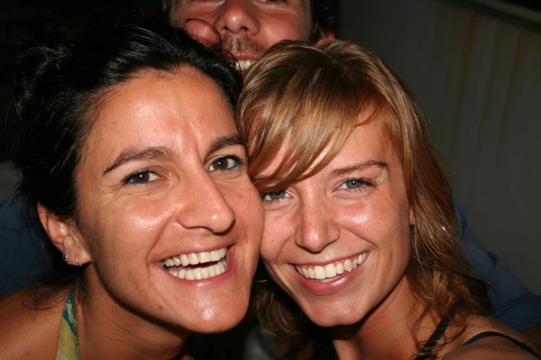 two women standing together, smiling for the camera