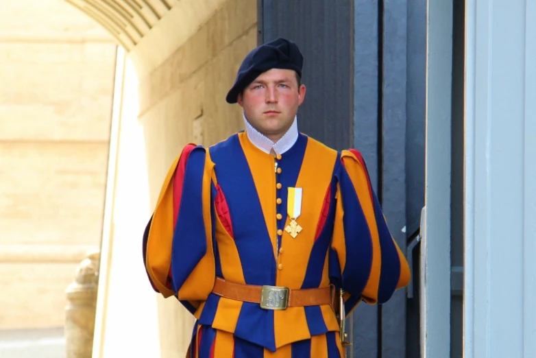 man in orange and blue costume standing on the outside of an building