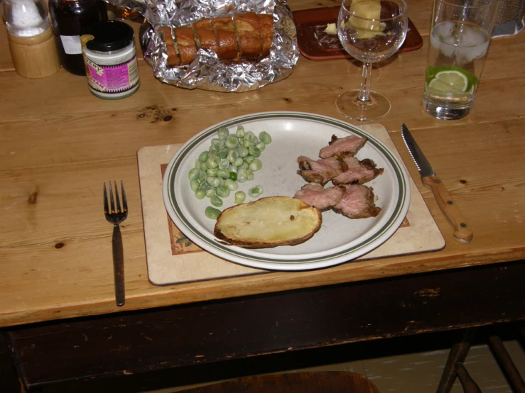 a plate with meat and potatos sits on a table