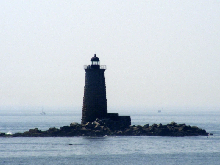 a lone light house on an island in the ocean