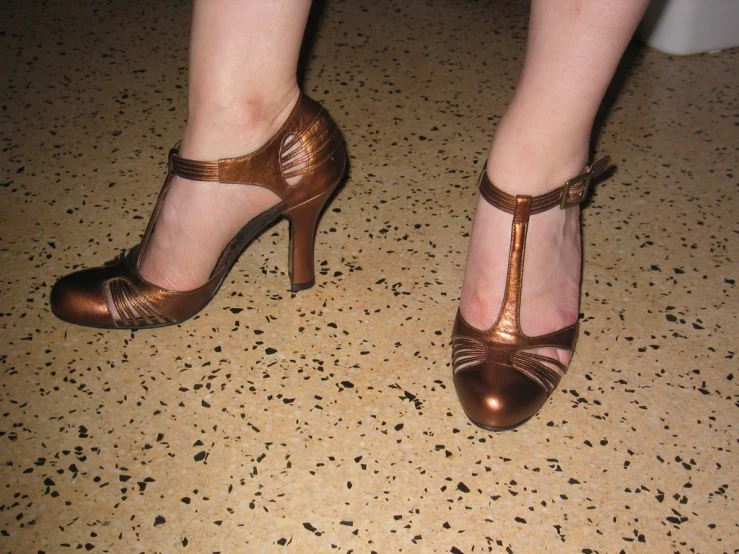 a woman wearing shoes and high heels with gold straps