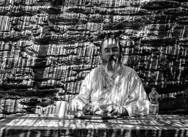 a man wearing elaborate clothing sits on a table