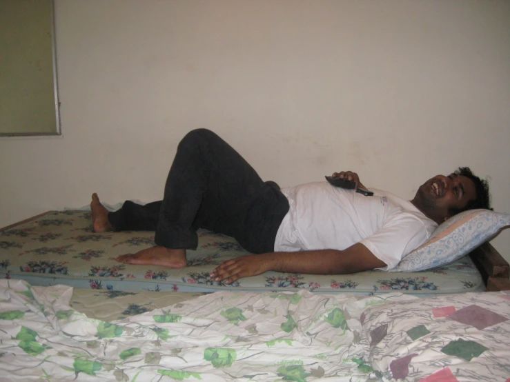 a man is laying on the edge of a bed