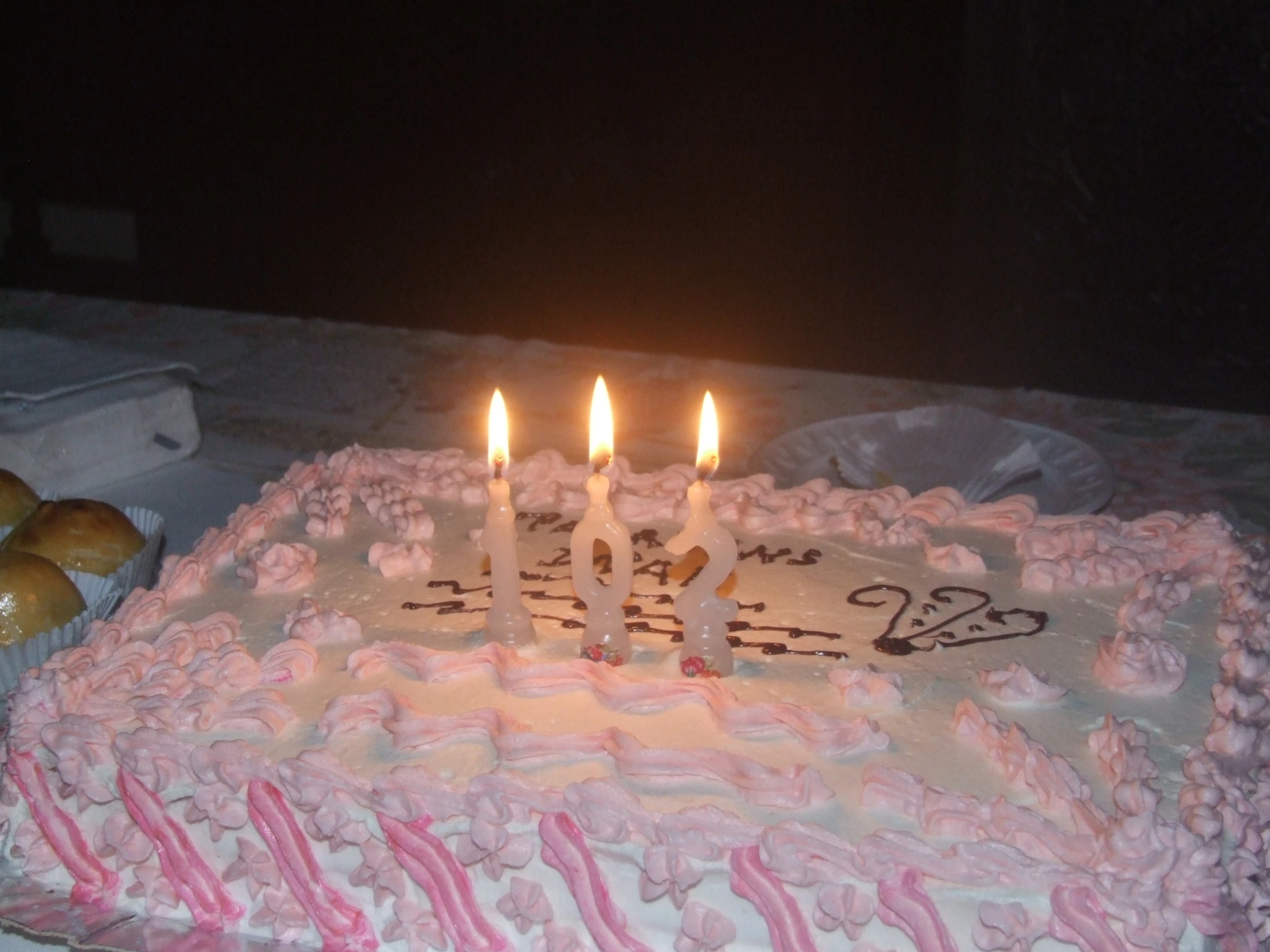 a birthday cake with white candles is on a table