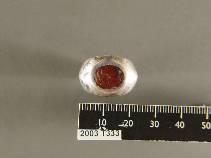 a small piece of silver with an orange stone