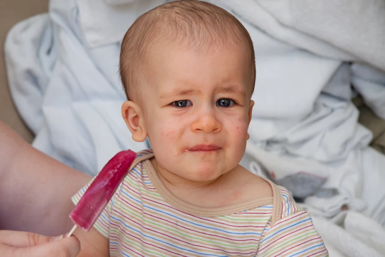 a baby with a toothbrush sticking out of it's mouth