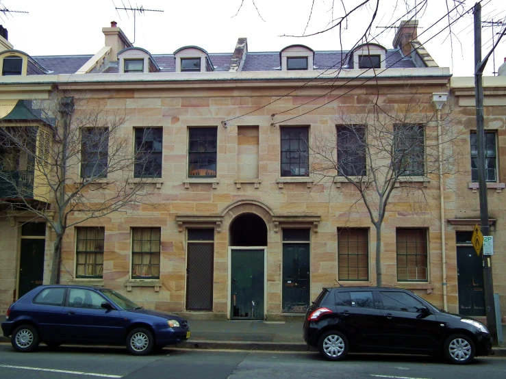 two cars parked outside of an old brick building